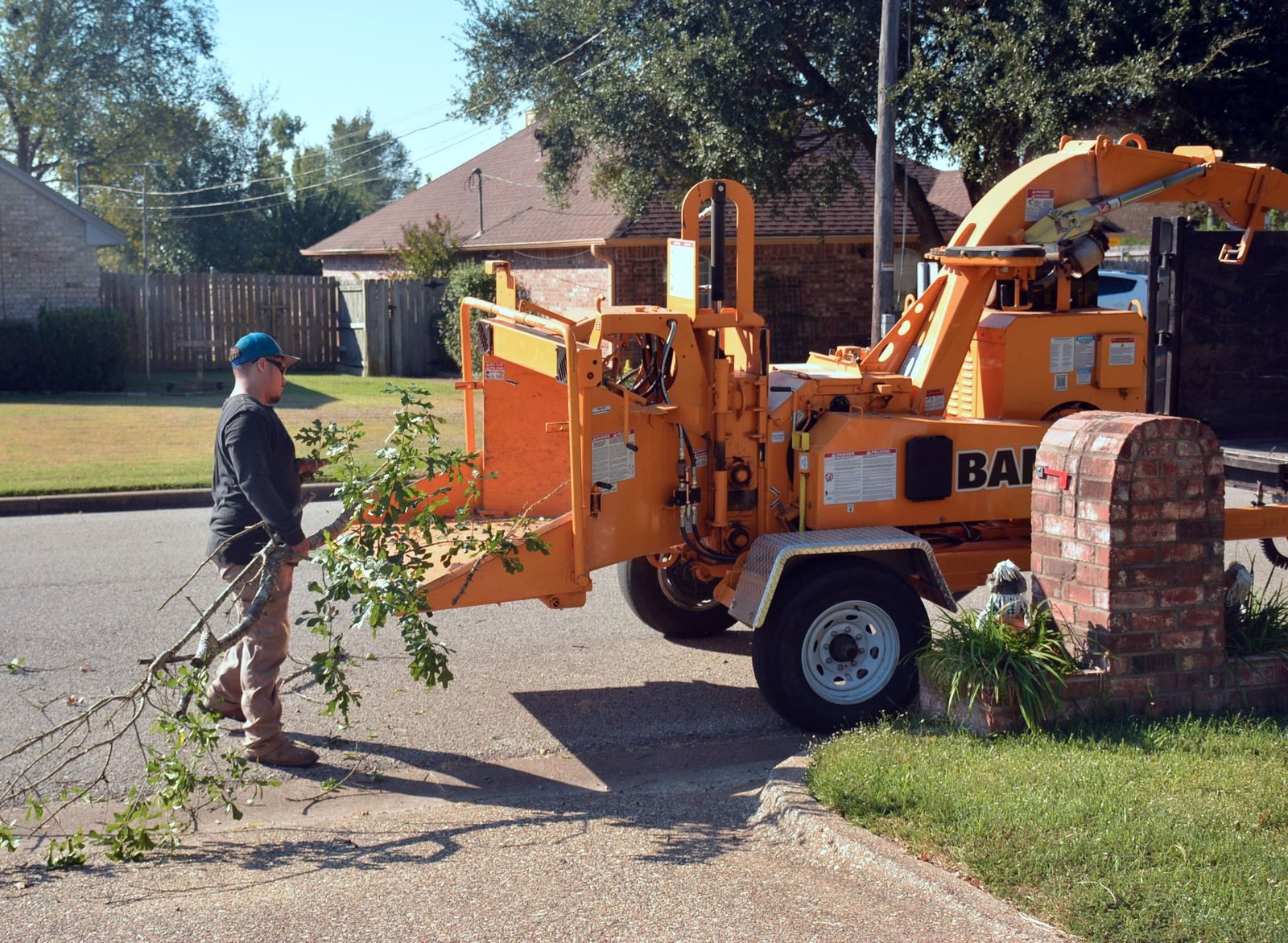 Operative feeding branches into a wood chipper during site clearance